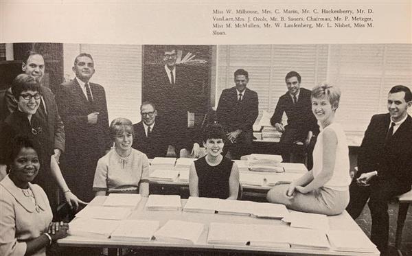 A 1968 yearbook photo of faculty seated around a table. 